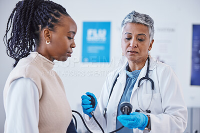 Buy stock photo Consultation, doctor and patient with blood pressure test and healthcare advice at clinic. Black woman consulting female medical professional, health care check and expert support or help at hospital