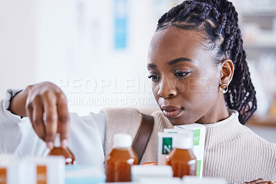 Buy stock photo Serious black woman, patient and medication on shelf for cure, illness or pain relief at pharmacy. African American female reading or looking at pharmaceutical products, medicine or drugs at clinic