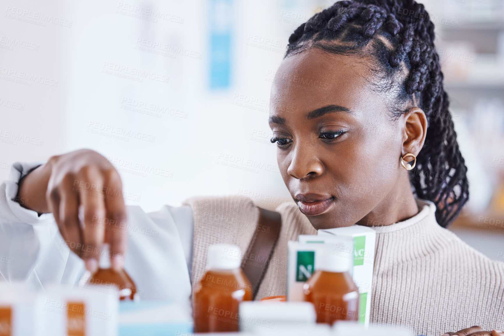 Buy stock photo Serious black woman, patient and medication on shelf for cure, illness or pain relief at pharmacy. African American female reading or looking at pharmaceutical products, medicine or drugs at clinic