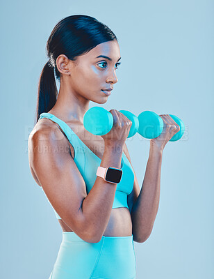 Buy stock photo Fitness, workout and woman with weights in a studio for a arm or strength training with motivation. Sports, health and Indian female athlete or model doing exercise while isolated by blue background.
