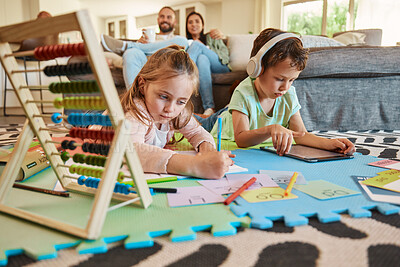 Buy stock photo Floor, learning and children with parents relax on sofa for education, creative writing and online digital games at home. Kids on carpet with tablet, headphones and stationery with family on couch
