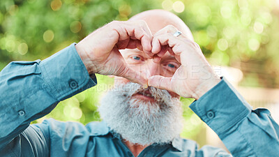 Buy stock photo Portrait, hands and heart with a senior man outdoor in a garden during summer for love or health. Face, emoji and shape with a hand gesture by a mature male outside in a park for wellness or romance