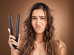 Hair care, electric straightener and portrait of sad woman on studio background, worried face and dry salon hairstyle. Haircare damage, flat iron and frustrated latino model with spa heat treatment.