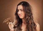 Beauty, crisis and sad woman in studio with hair loss, dry and damage against brown background. Haircare, fail and girl model frustrated with weak, split ends or alopecia while posing isolated