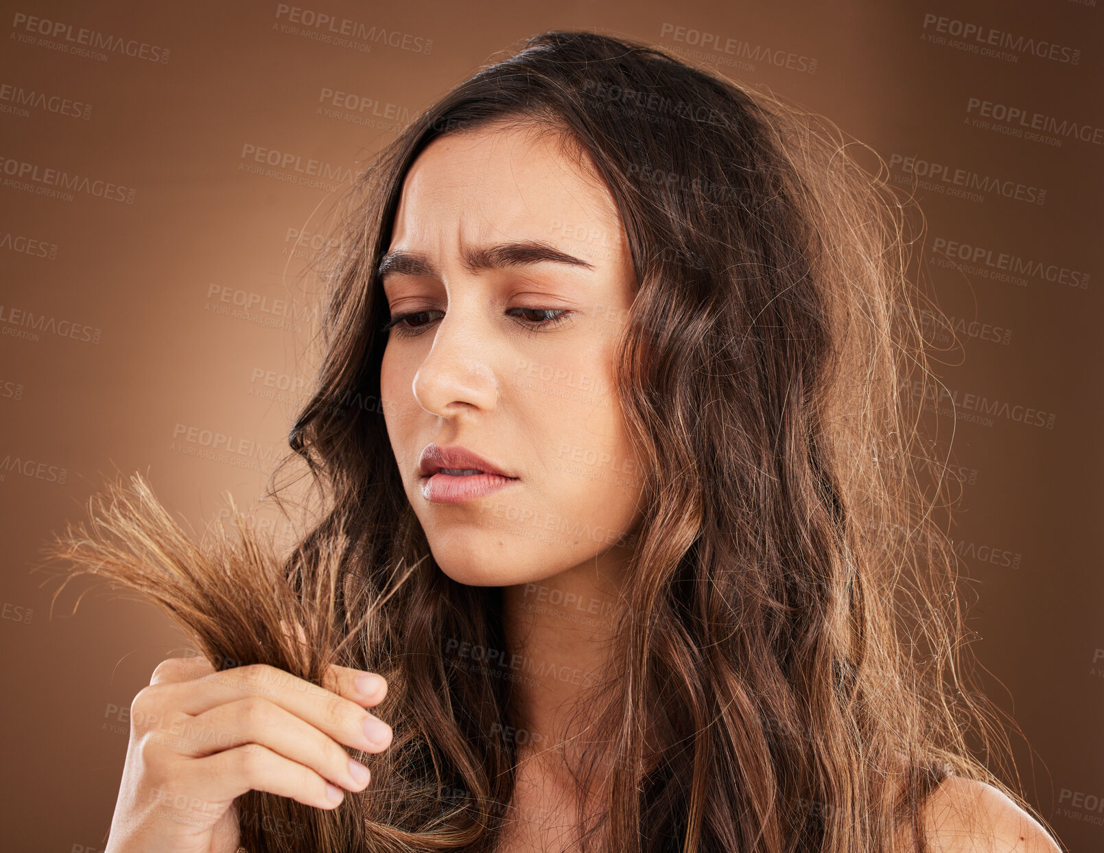 Buy stock photo Split ends, hair damage and woman in studio for frustrated, crisis and textures with salon treatment. Beauty, repair and haircut with female model on brown background for keratin and cosmetology