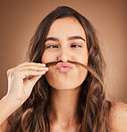 Hair care, comic moustache and face of woman for wellness, hairstyle and health on brown background. Salon aesthetic, treatment and girl with cosmetics, keratin treatment and natural beauty in studio