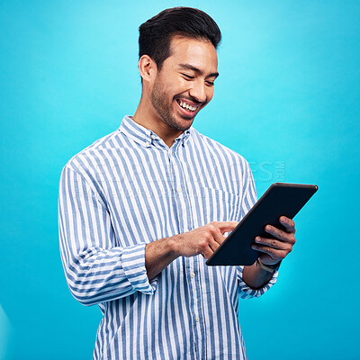 Buy stock photo Tablet, man and smile in a studio on social media, internet and website app scroll. Happiness, isolated, and blue background with a male model reading a ebook on a digital networking application