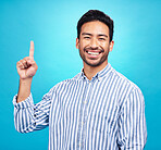 Point, excited and portrait of man on blue background for news, information and announcement. Advertising, studio mockup and face of happy male pointing for copy space, promotion and showing gesture