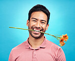 Teeth, flower and portrait of man in studio for celebration, gift and romance. Funny, goofy and present with male isolated on blue background for happiness, smile and valentines day mockup