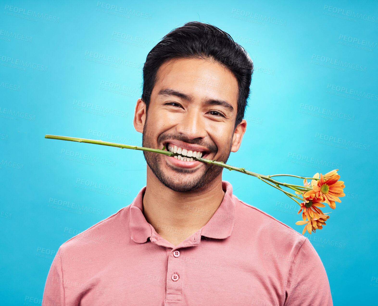 Buy stock photo Teeth, flower and portrait of man in studio for celebration, gift and romance. Funny, goofy and present with male isolated on blue background for happiness, smile and valentines day mockup