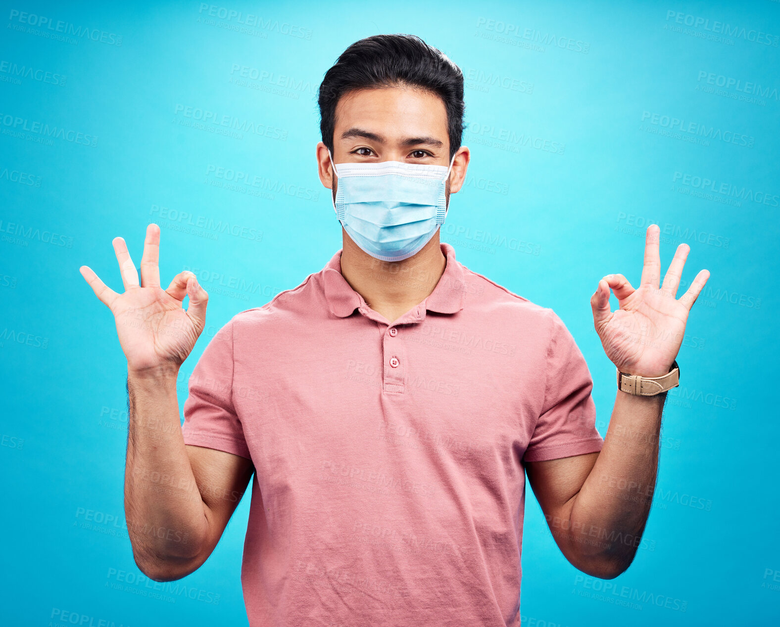 Buy stock photo Man in face mask, portrait and covid with okay hand gesture, safety from virus and bacteria isolated on blue background. Disease, corona and male person with emoji and health compliance in studio