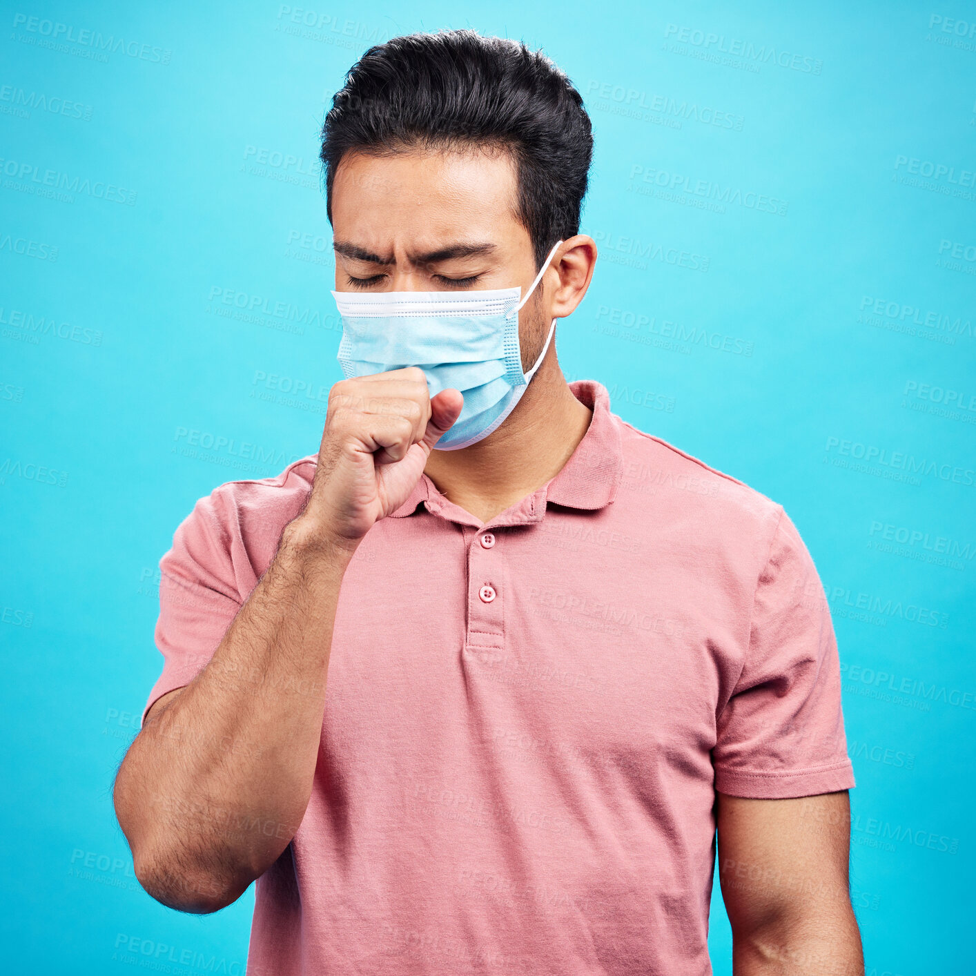 Buy stock photo Covid cough, sick and a man with a cold isolated on a blue background in a studio. Healthcare, virus and an Asian person coughing with a face mask for flu, infection and disease during pandemic