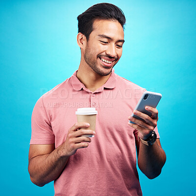 Buy stock photo Smile, coffee and man with phone in studio isolated on a blue background. Tea, cellphone and happiness of Asian person with drink, caffeine and mobile for social media, typing online or texting.