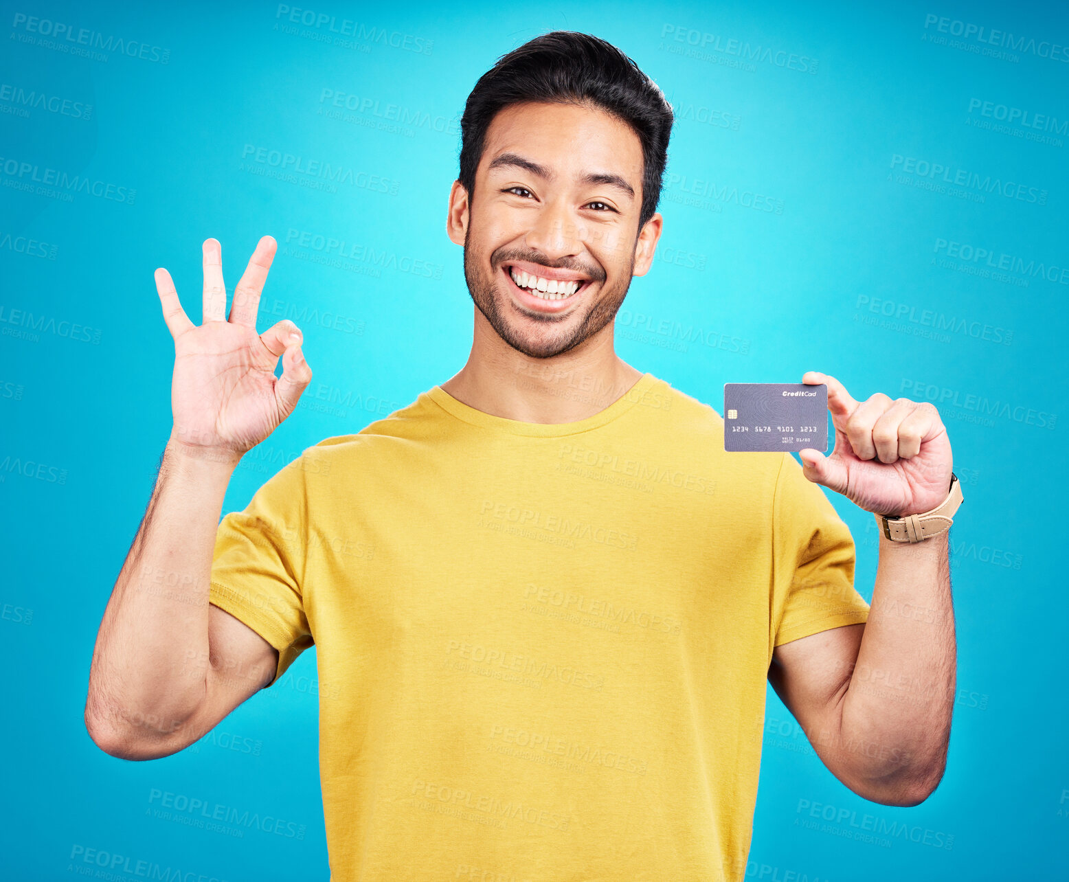 Buy stock photo Credit card, okay and portrait of man isolated on blue background for shopping, e commerce and payment loan. Happy asian person, excited for banking solution, financial savings and ok emoji in studio