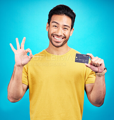 Buy stock photo Ok, credit card and man in portrait isolated on blue background for shopping, e commerce and payment loan. Happy asian person, excited for banking solution, financial savings and okay emoji in studio