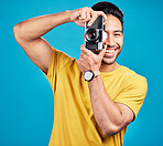 Happy, photographer and man with a camera in a studio for creative or artistic photoshoot. Photography, happiness and portrait of a male person with a hobby for memories isolated by a blue background