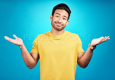 Buy stock photo Confused, question and portrait of man shoulder shrugging and raise arms isolated in a blue studio background. Clueless, smile and young male person with doubt, whatever and doing a hand gesture