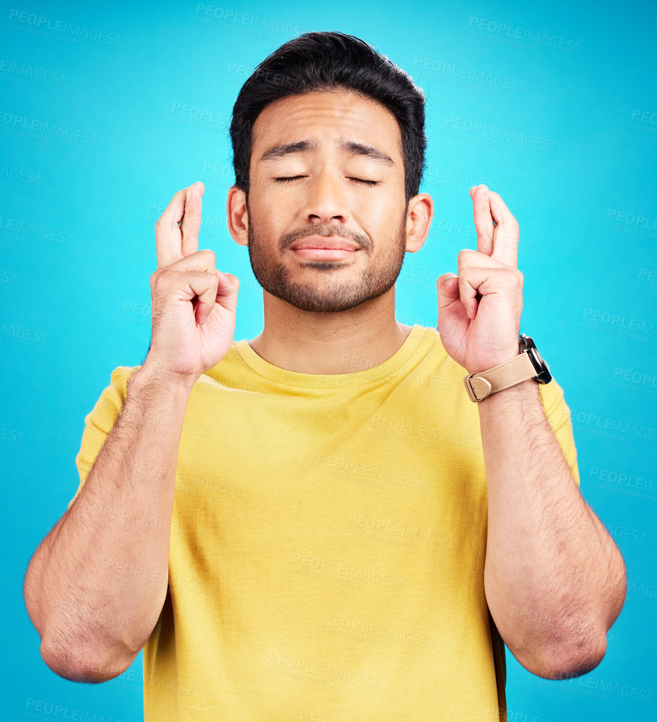 Buy stock photo Hope, man and fingers crossed for miracle in studio isolated on a blue background. Wish, hand gesture or male person with aspiration, hopeful emoji and wait for good fortune, luck or optimistic faith