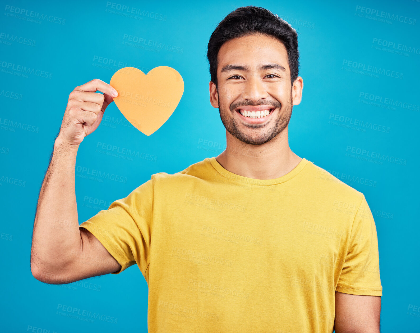 Buy stock photo Portrait, cutout heart and Asian man with smile, support and loving against blue studio background. Face, male person and model with symbol for love, happiness and emoji with wellness and confident
