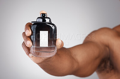 Buy stock photo Hand, bottle and cologne with a man in studio on a gray background holding a perfume fragrance product. Luxury scent, glass and spray with a male showing a container of cosmetics for a fresh smell