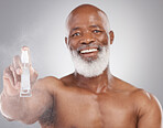 Portrait, beauty and product with a senior man holding an antiaging serum in studio on a gray background. Face, beard care and cosmetics with a mature male spraying a facial treatment for skincare