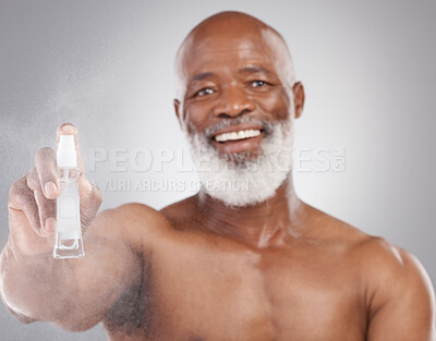 Buy stock photo Portrait, beauty and product with a senior man holding an antiaging serum in studio on a gray background. Face, beard care and cosmetics with a mature male spraying a facial treatment for skincare