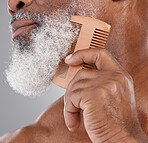 Man, hands and closeup of beard with comb in grooming, beauty or skincare hygiene against a studio background. Senior male neck and chin combing or brushing facial hair for clean wellness or haircare