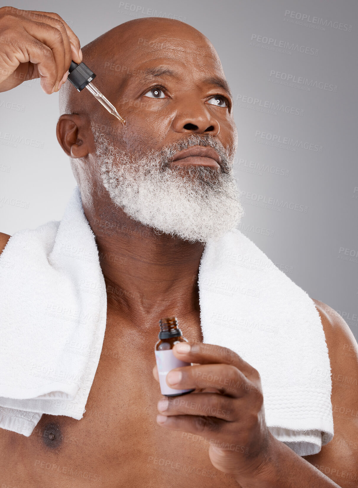 Buy stock photo Skincare, health and male with face serum in a studio for a natural, beauty and skin treatment. Cosmetic, wellness and senior man model with facial oil for a dermatology routine by a gray background.