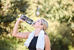 Fitness, runner or girl drinking water in park to hydrate, relax or healthy energy on exercise break in nature. Tired thirsty athlete woman refreshing with liquid for hydration in training or workout