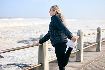 Buy stock photo Woman, runner and stretching legs at the beach for training, running and morning cardio routine outdoors. Run, warm up and stretch before fitness, exercise and sports workout along the ocean