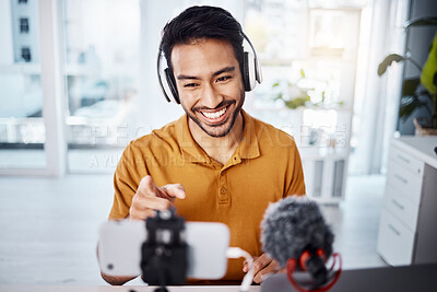 Buy stock photo Podcast, pointing and live streaming with a man influencer recording broadcast content in his home office. Internet, streamer and subscription with a male freelancer or creator working in his studio