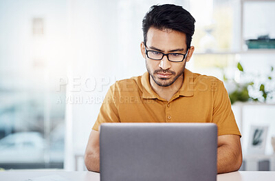 Buy stock photo Serious, work and an Asian man with a laptop in a home office for communication, email and internet. Business, research and an entrepreneur or freelance worker typing a proposal on a computer