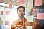 Planning, writing and focused man on glass for project management, workflow and business schedule. Asian person brainstorming ideas, moodboard and sticky notes for solution, reminder or job priority