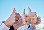Business people, hands and thumbs up in agreement, thank you or good job for teamwork in the outdoors. Hand of group showing thumb emoji, yes sign or like for team success, ok or approval on blue sky