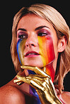 Woman, gold hand and beauty with color paint cosmetics on skin and face in studio. Female model person on a black background for art deco, fantasy and creative rainbow makeup for lgbtq or gay pride