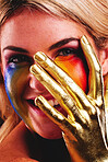 Gold hand, woman and beauty portrait with color paint cosmetics on skin and face in studio. Female model person with a happy smile for art deco, fantasy and creative makeup with metallic shine