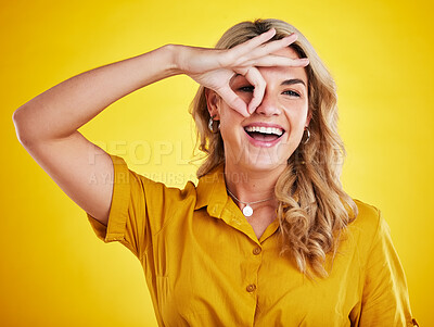 Buy stock photo Portrait, happy woman and okay on eyes for good review,  motivation and sign on yellow background. Female person, funny face and ok hands for agreement, support and yes to emoji, thank you or winning