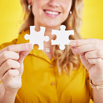 Buy stock photo Hands, puzzle and woman in studio for problem solving, solution and innovation on a yellow background. Jigsaw, mission and closeup person, happy for answer, strategy and creative brainstorming plan