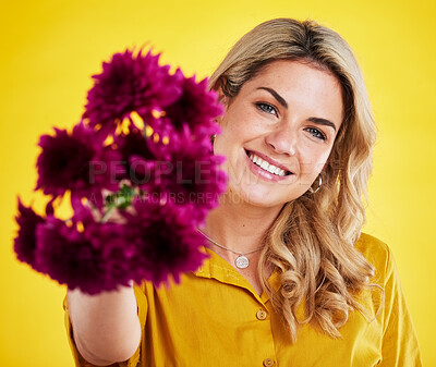 Buy stock photo Portrait, happiness and woman giving flowers in studio isolated on a yellow background. Floral, bouquet present and smile of female person holding gift of natural plants, purple flower or dahlia.