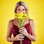 Portrait, happiness and woman smelling flowers in studio isolated on a yellow background. Floral, bouquet and female person sniff aroma or scent of natural plants and fresh flower for spring.