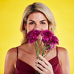 Portrait, smell and woman with flowers, beauty and confident girl against a studio background. Face, female person and model with plants, natural care and floral present with lady, bouquet and scent