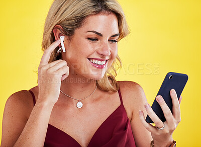 Buy stock photo Phone, music earphones and happiness of woman in studio isolated on a yellow background. Cellphone, radio and female person listening, hearing and streaming audio album, sound track or podcast.
