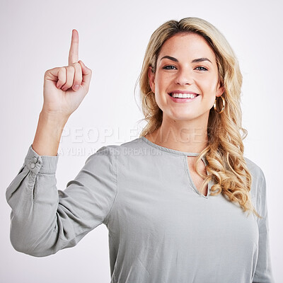 Buy stock photo Woman, portrait and pointing finger up with a smile for hope, religion and God isolated on a white background. Female person with a hand gesture for direction, happiness and presentation in studio