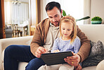 Child, dad and a tablet for learning in a family home while reading or playing a game for education. A man or father and girl kid on a sofa streaming internet, mobile app and website for development 