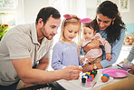 Family, painting and eggs with kids learning to be creative on table at easter or color brush at home. Children, mother and father happy decorating together or dad with mom teaching young girl art. 