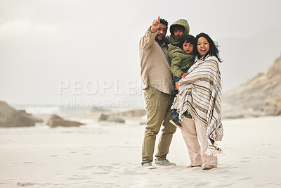 Buy stock photo Mother, father and children at the beach for family time in winter with love and care outdoor in nature. Man, woman and kids on a vacation, holiday or travel trip for bonding and pointing at mockup