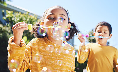 Buy stock photo Boy, girl and playing with bubbles outdoor in garden, backyard or park with happiness, family or siblings. Children, soap bubble game and playful in childhood, youth and summer sunshine on holiday