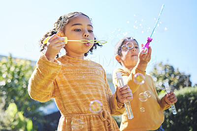 Buy stock photo Playing, garden and children blowing bubbles for bonding, weekend activity and fun together. Recreation, outdoors and siblings with a bubble toy for leisure, childhood and enjoyment in summer