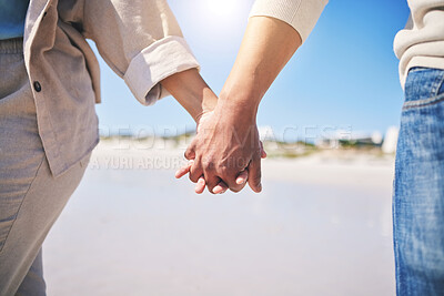 Buy stock photo Holding hands, love and a couple walking on the beach for romance, support or a date. Content, vacation and a man and woman with affection on a walk at the ocean for commitment and trust together