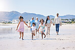 Beach, big family and children holding hands, running and happiness on summer vacation together in Mexico. Sunshine, fun and bonding, men, women and kids on holiday walk on happy morning with energy.